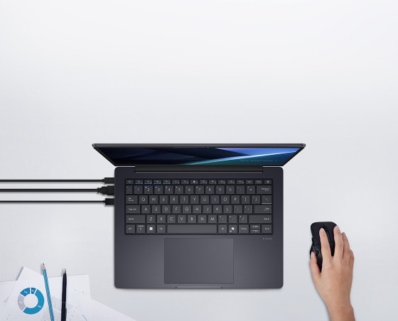The top view of ASUS ExpertBook B3 with 3 cords connected to the left side of the device, with a hand using mouse on the right side of the device. 